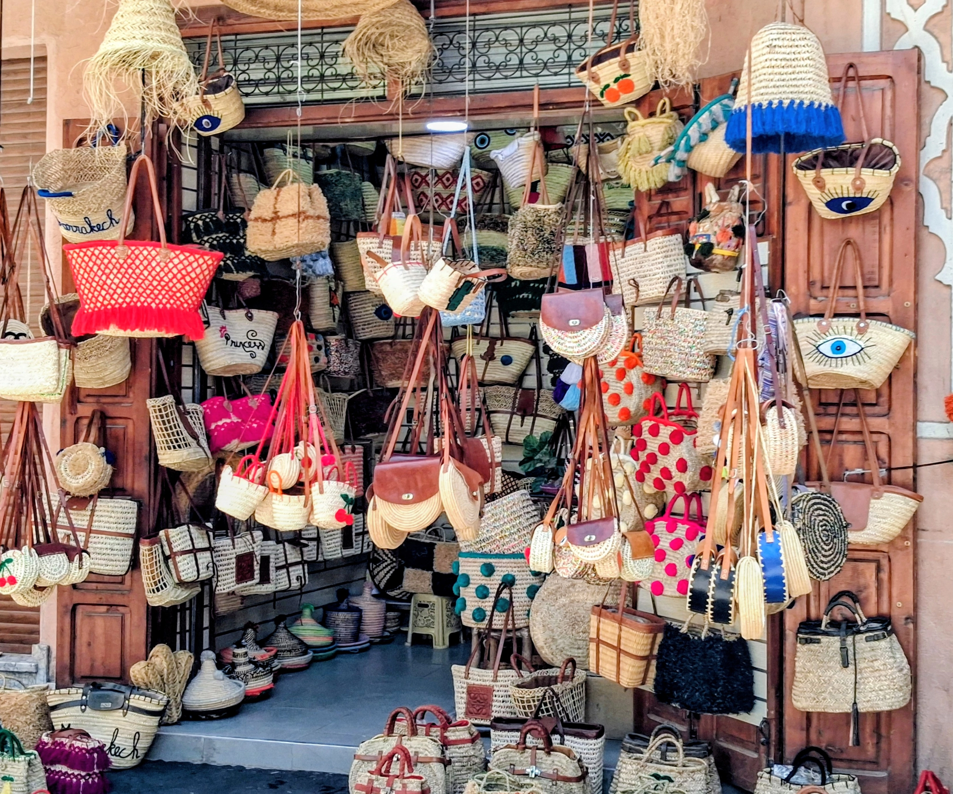 Étal coloré d'une échoppe dans les souks de Marrakech proposant une grande variété de paniers, cabas et sacs en osier tressé.